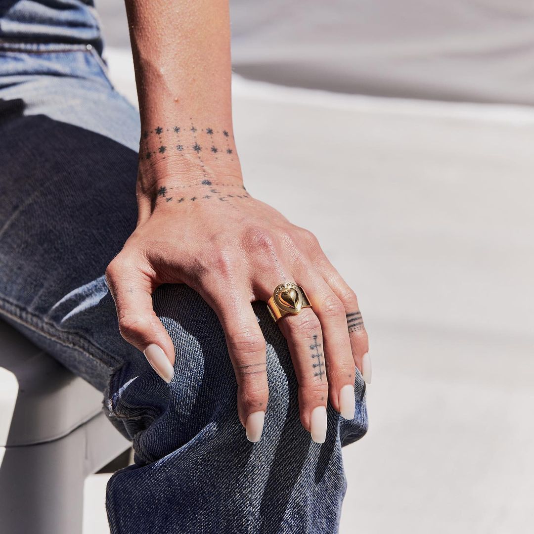 Girl shows her hand on her knee wearing a Puff Heart Cigar Band Ring