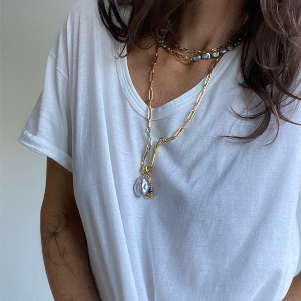 Load image into Gallery viewer, Woman with brown hair wearing a white t shirt and gold colored and pearl jewelry with a gold colored charm necklace