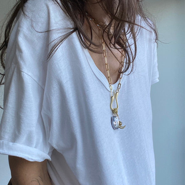 Load image into Gallery viewer, Woman with brown hair wearing a white t shirt and gold colored and pearl jewelry with a gold colored charm necklace