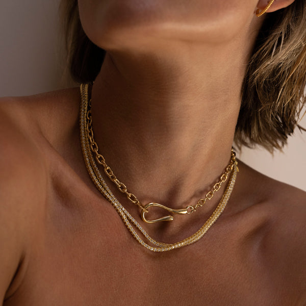 Woman wearing large hook and loop necklace with 2 tennis necklaces