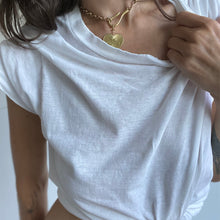 Load image into Gallery viewer, Woman with brown hair wearing a white t shirt and gold colored Necklace with Heart Charm
